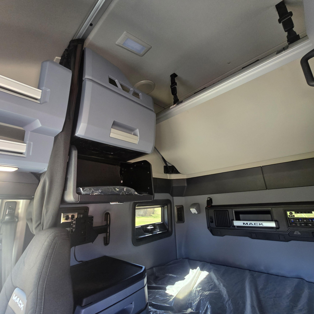 Mack PR64T76H truck cab interior showing overhead bunk area and storage cabinets.