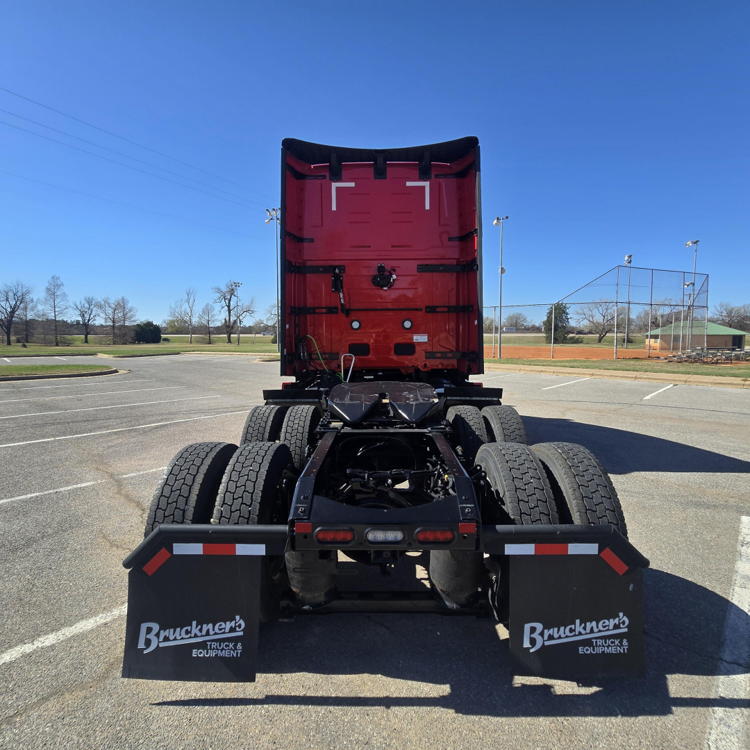 Rear view of a red Mack PR64T76H tractor cab with chassis and dual rear axles, mud flaps labeled Bruckner's Truck & Equipment.