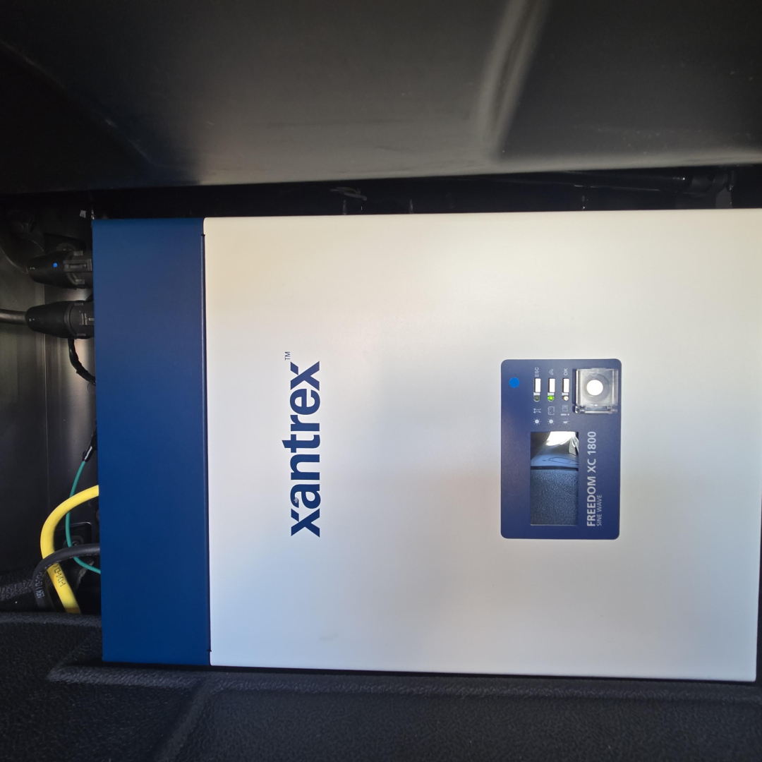 Mack PR64T76H engine area with Xantrex power inverter unit labeled Xantrex on a white panel.