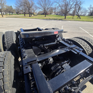 Chassis view of a 2026 Mack PR64T76H truck showing the frame, drive axles, and suspension components from an elevated angle.