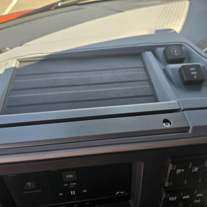 Mack PR64T76H interior view showing dash with storage area and control switches. In-picture text not clearly legible