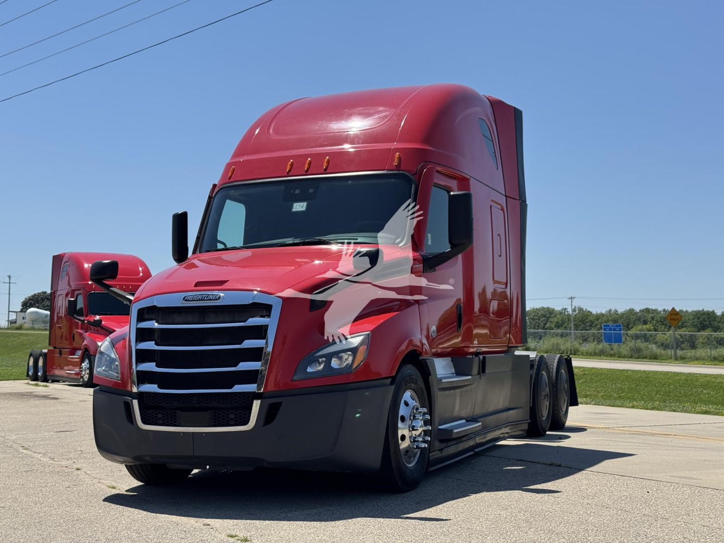Freightliner Cascadia 126 tractor unit in red, front-left view, sleeper cab, daylight, highway setting.
