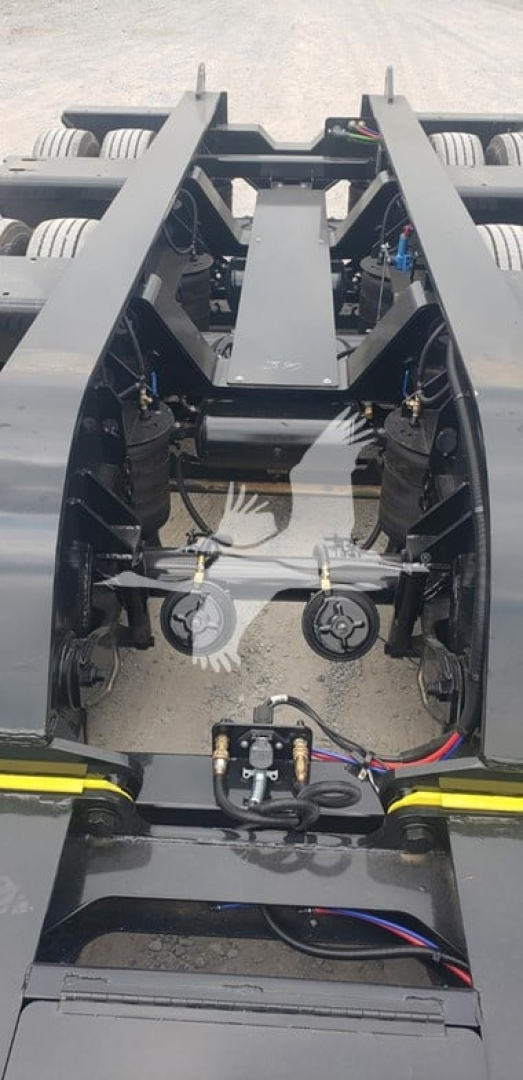 Machine hitch area of a Fontaine 55Mx trailer showing hydraulic hoses, coupling mechanisms, and metal frame rails.