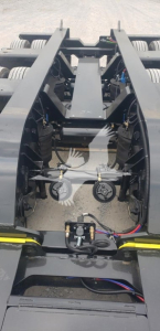 Machine hitch area of a Fontaine 55Mx trailer showing hydraulic hoses, coupling mechanisms, and metal frame rails.