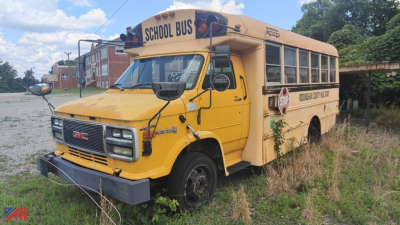 Yellow GMC Thomas school bus showing exterior with 'SCHOOL BUS' sign on roof and stop sign arm extended.