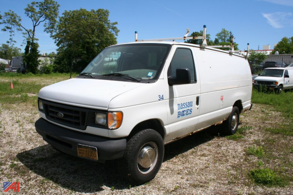 Ford E-Series cargo van showing Nassau Boces lettering and utility rack on roof, front-left view