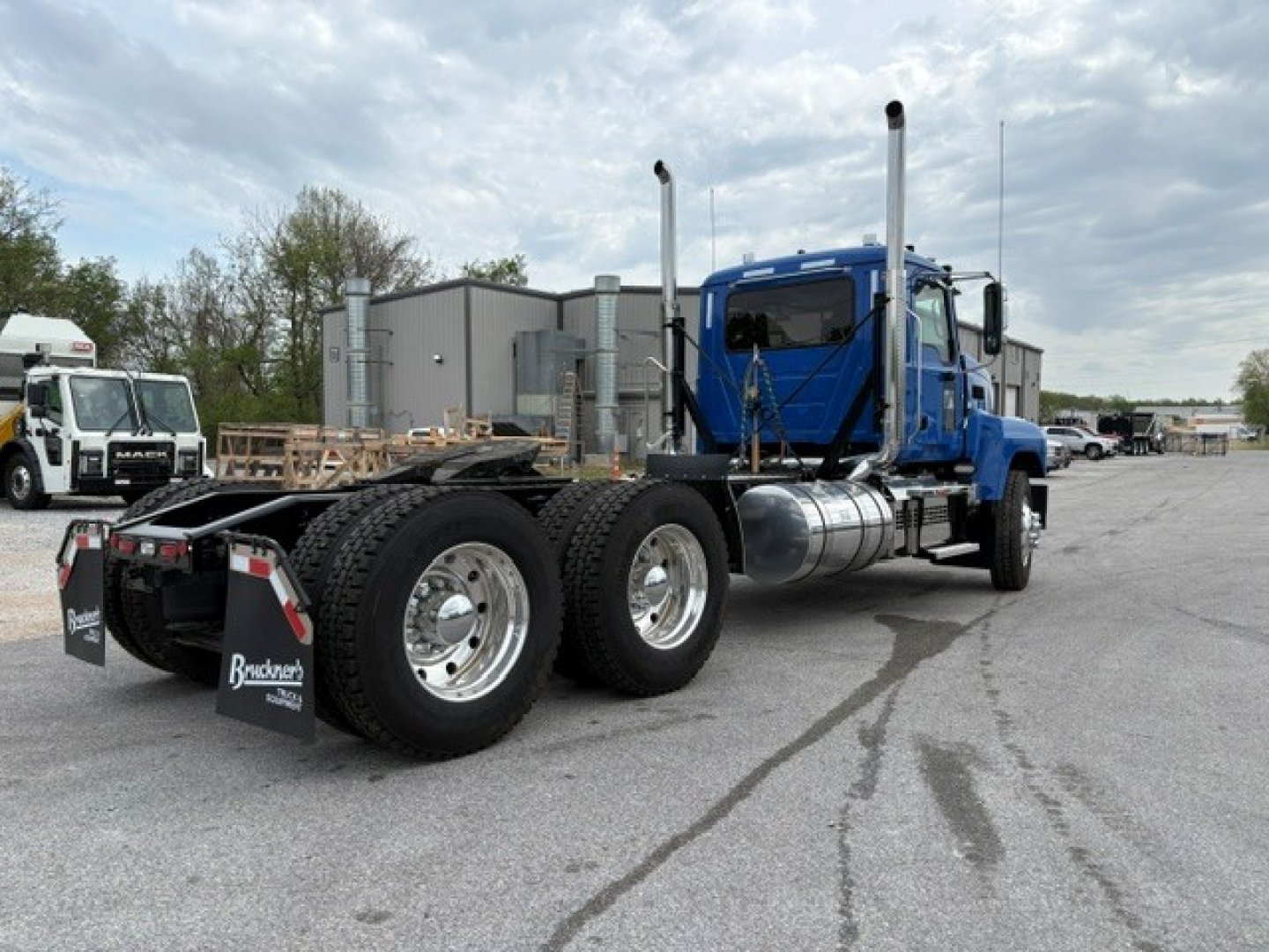 Mack PI64T conventional daycab tractor showing side view with dual rear axles and blue cab.