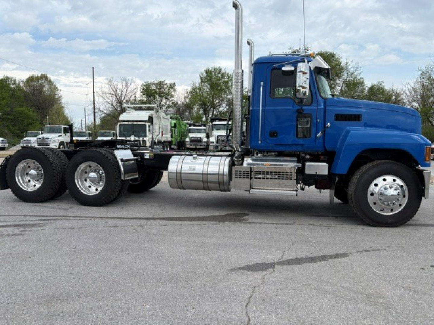 Mack PI64T truck chassis side view showing blue cab and large fuel tank with exhaust stack.