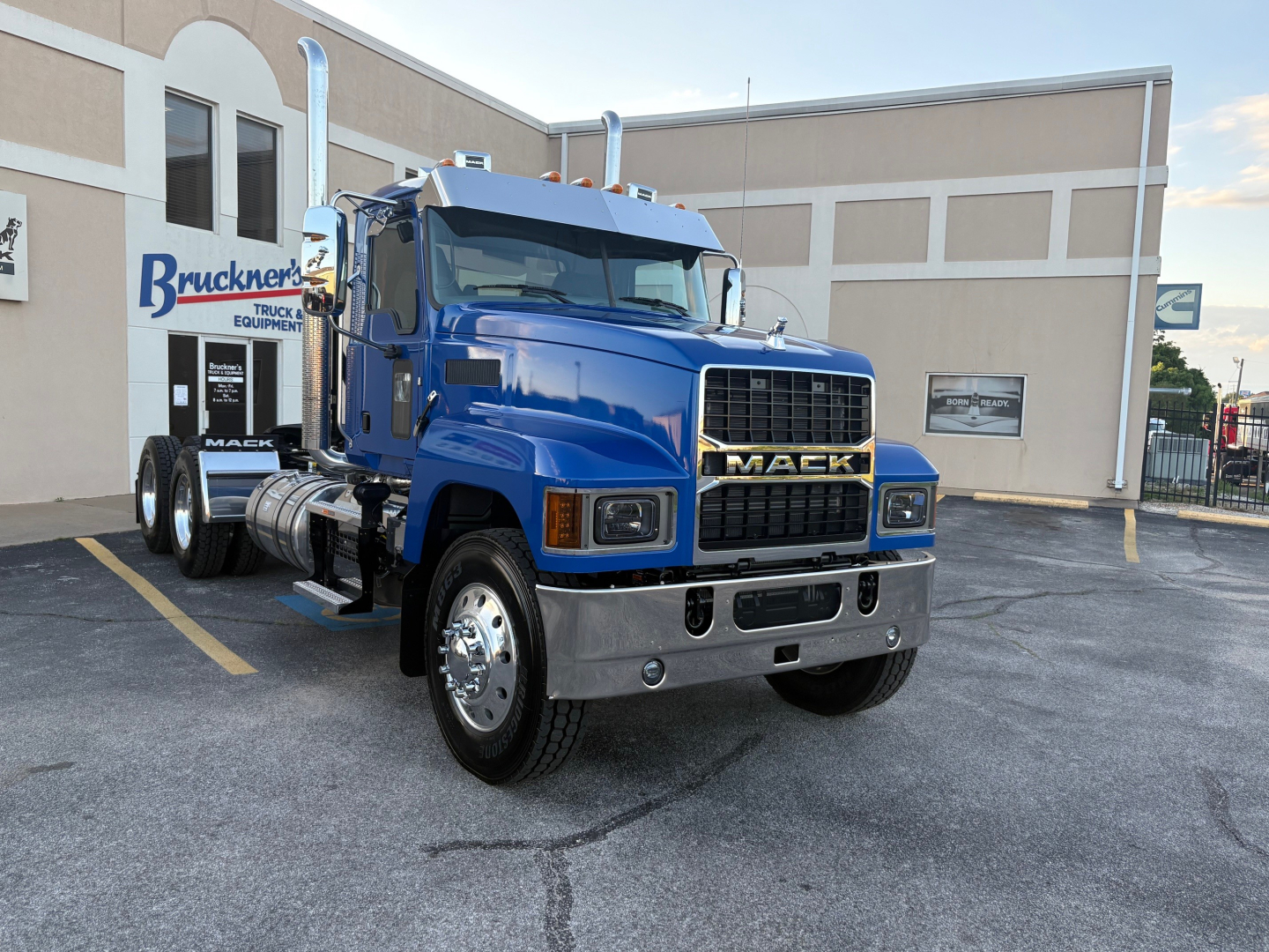 Mack PI64T truck in blue parked in lot showing front grille with MACK badge and bumper; new conventional daycab tractor.