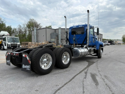 Mack PI64T conventional daycab tractor showing side view with dual rear axles and blue cab.