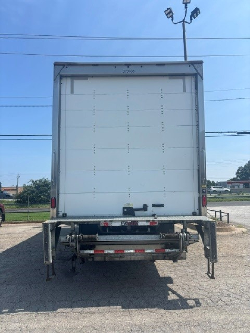 Box truck rear view showing cargo area with closed white doors, taillights, and rear underride guard. VIN and stock not visible.