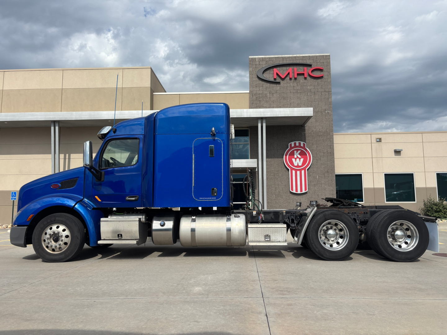 Peterbilt 579 truck in blue cab with sleeper, side view showing chassis and tandem rear axles