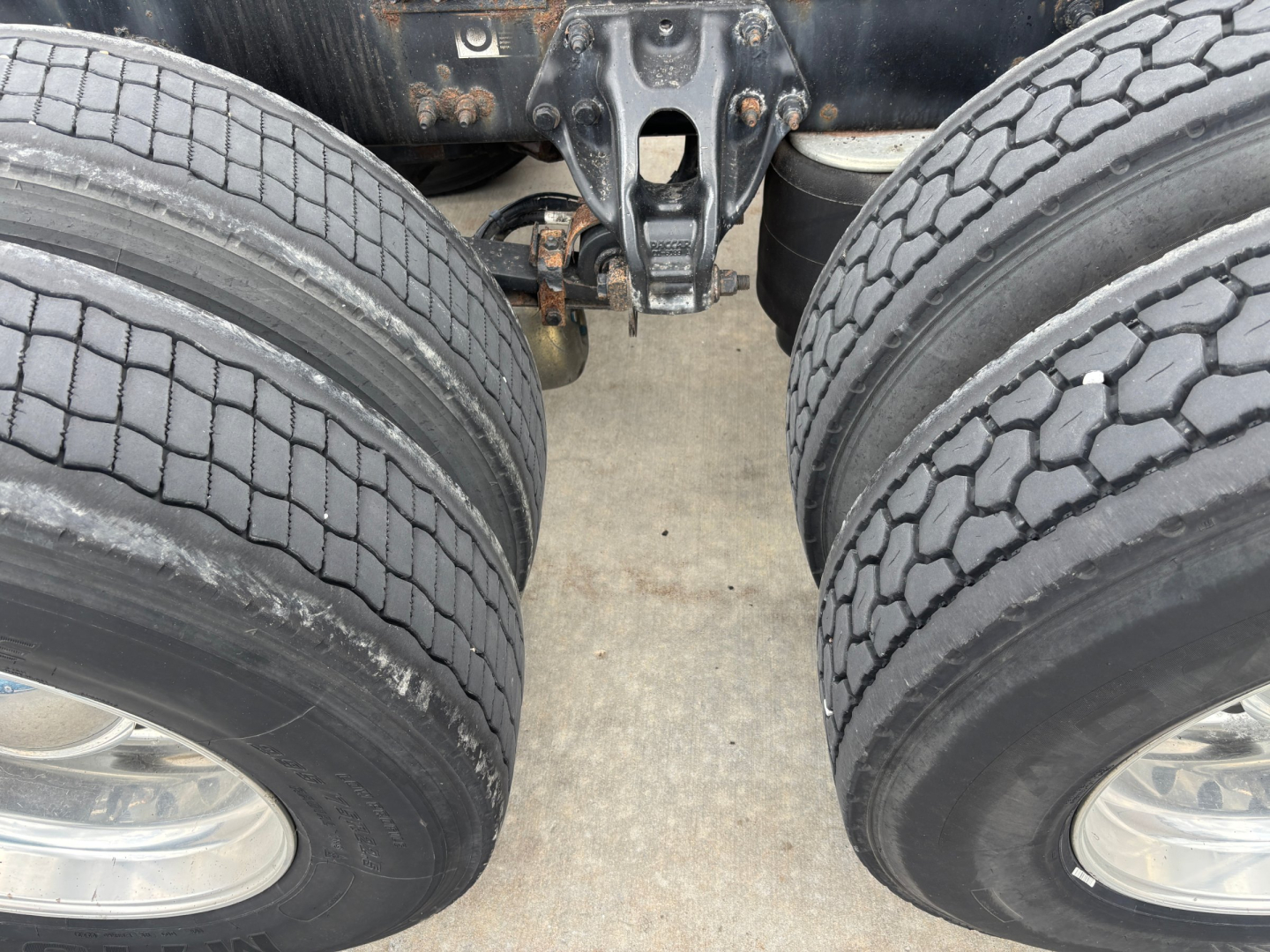 Peterbilt 579 truck dual rear axles with view of suspension and tires, showing wheels and hitch area.
