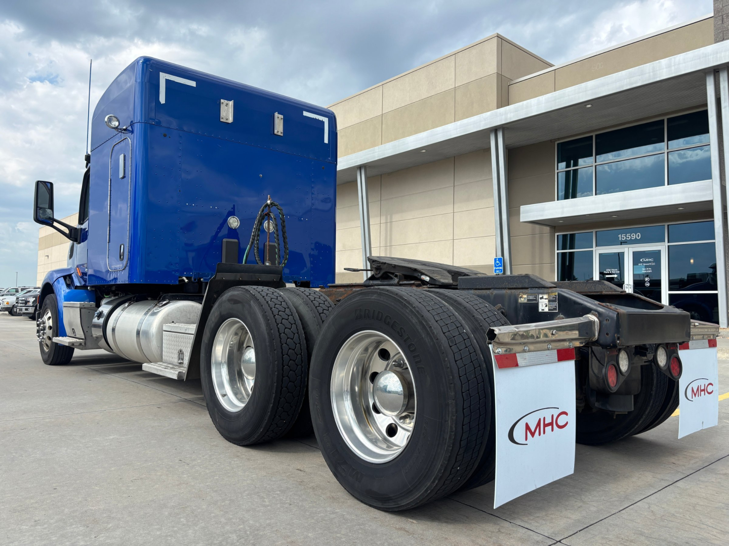 Peterbilt 579 truck tractor rear view showing dual rear axles and fuel tanks.