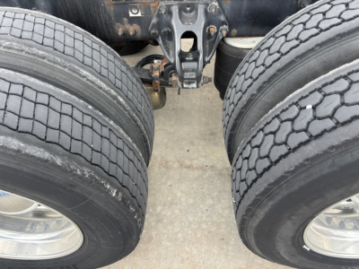 Peterbilt 579 truck dual rear axles with view of suspension and tires, showing wheels and hitch area.