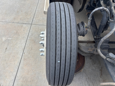 Peterbilt 579 front wheel and axle showing tire treads and wheel hub assembly.