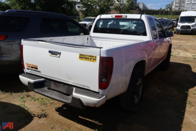 Chevrolet Colorado pickup truck 2010 rear view showing cargo bed with stickers and tailgate in white, 4x4.