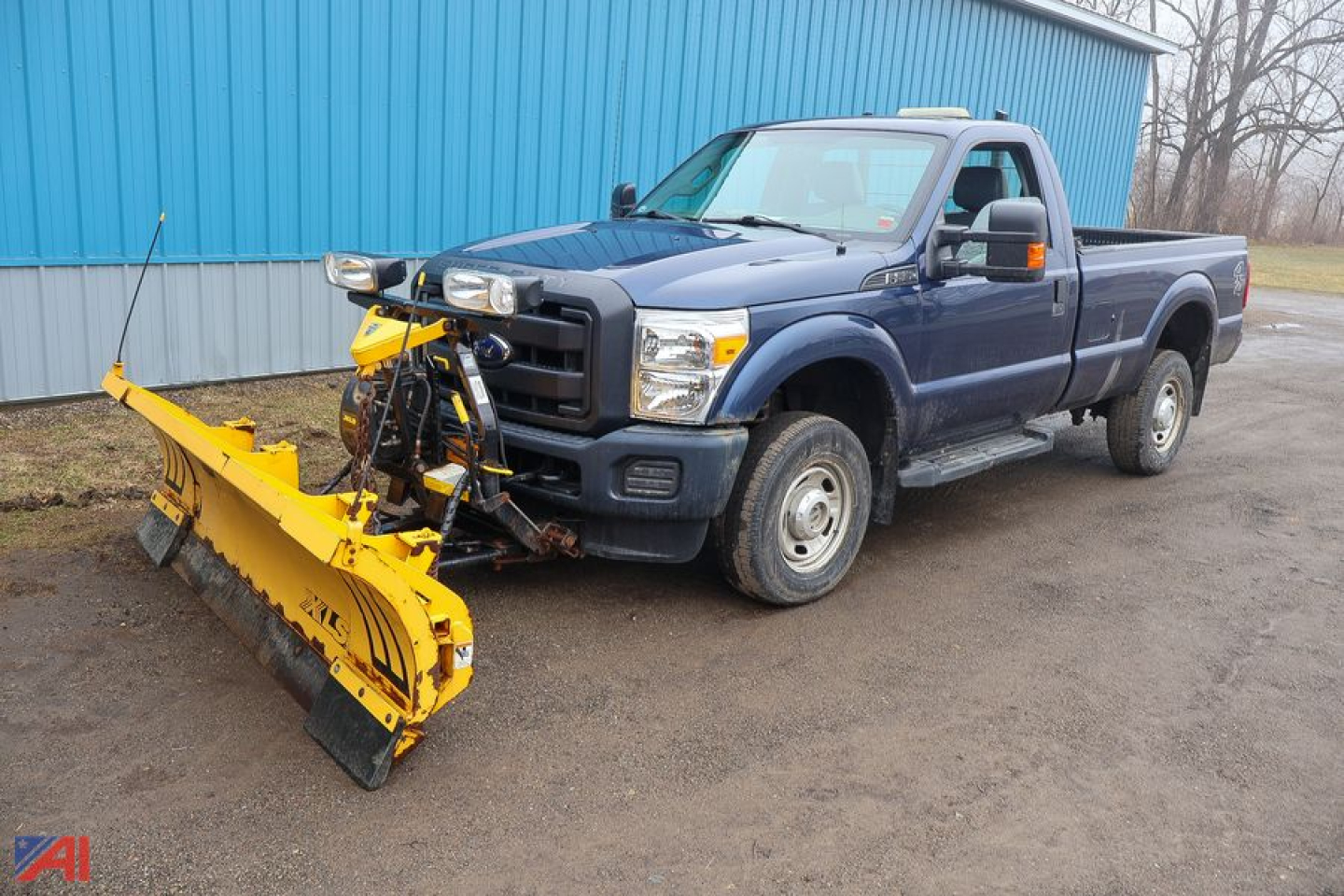 Ford F-350 Super Duty pickup with a large yellow snow plow attachment mounted to the front, blue body, extended cab, in-service condition.