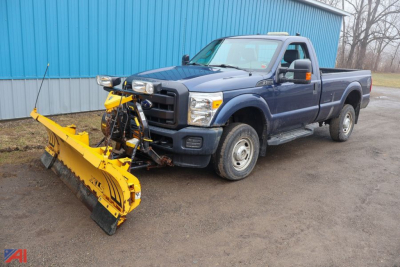 Ford F-350 Super Duty pickup with a large yellow snow plow attachment mounted to the front, blue body, extended cab, in-service condition.