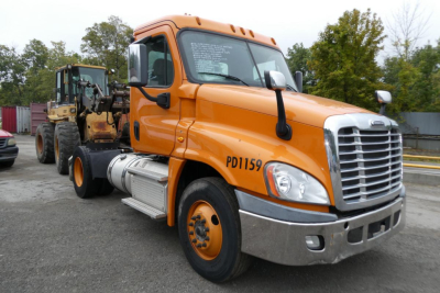 Orange Freightliner Cascadia 125 daycab truck with chrome bumper and fuel tanks, side view showing PD1159 number, on a lot.