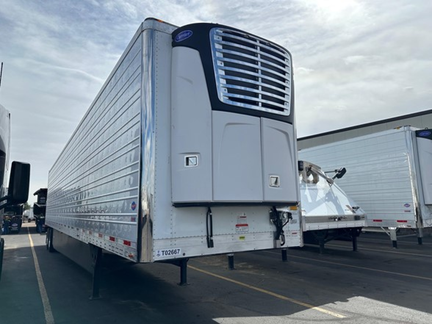 Trailer side and front refrigeration unit of a 2026 Utility 3000R reefer trailer showing the front cooling unit and silver corrugated side walls.
