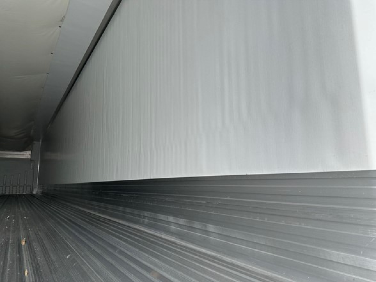 Trailer interior side wall and floor of a new 2026 Utility 3000R reefer trailer showing metal interior wall panels and ribbed floor.