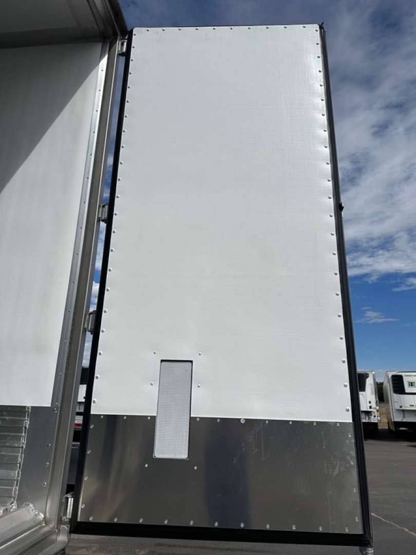 Trailer rear door of a 2026 Utility 3000R reefer trailer showing tall insulated panel with riveted edges and a small access panel at bottom.