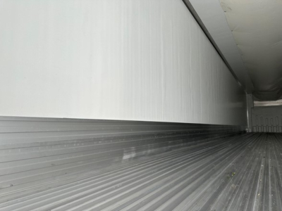 Trailer interior showing corrugated metal flooring and sidewall, empty reefer trailer cargo area.