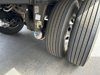 Trailer dual rear tires and suspension components of a new 2026 Utility 3000R reefer trailer showing wheel hubs, leaf spring and hitch area.