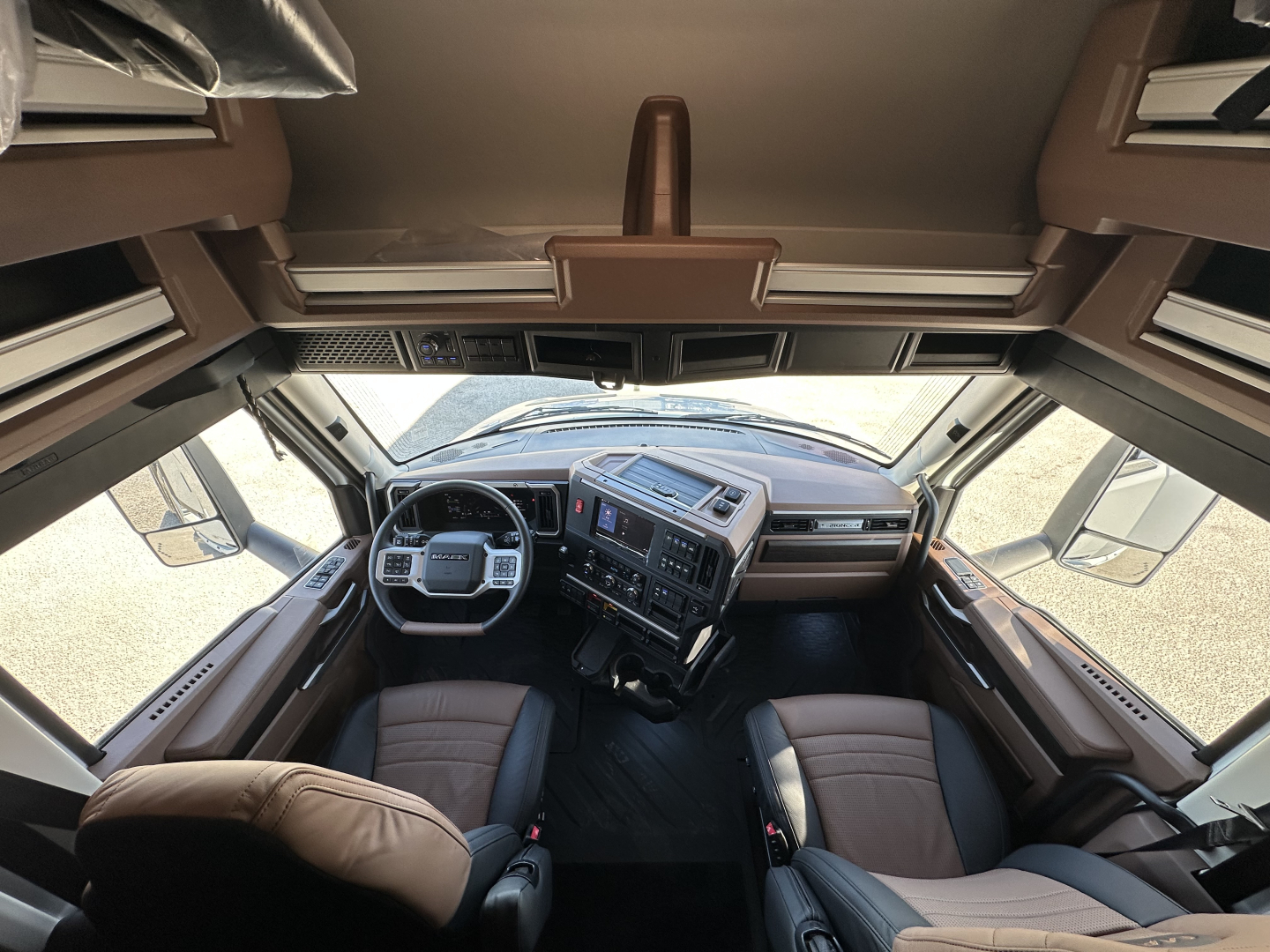 Cab interior of a 2026 Mack PR64T64 truck showing dashboard, steering wheel, and seating from a front-view perspective.