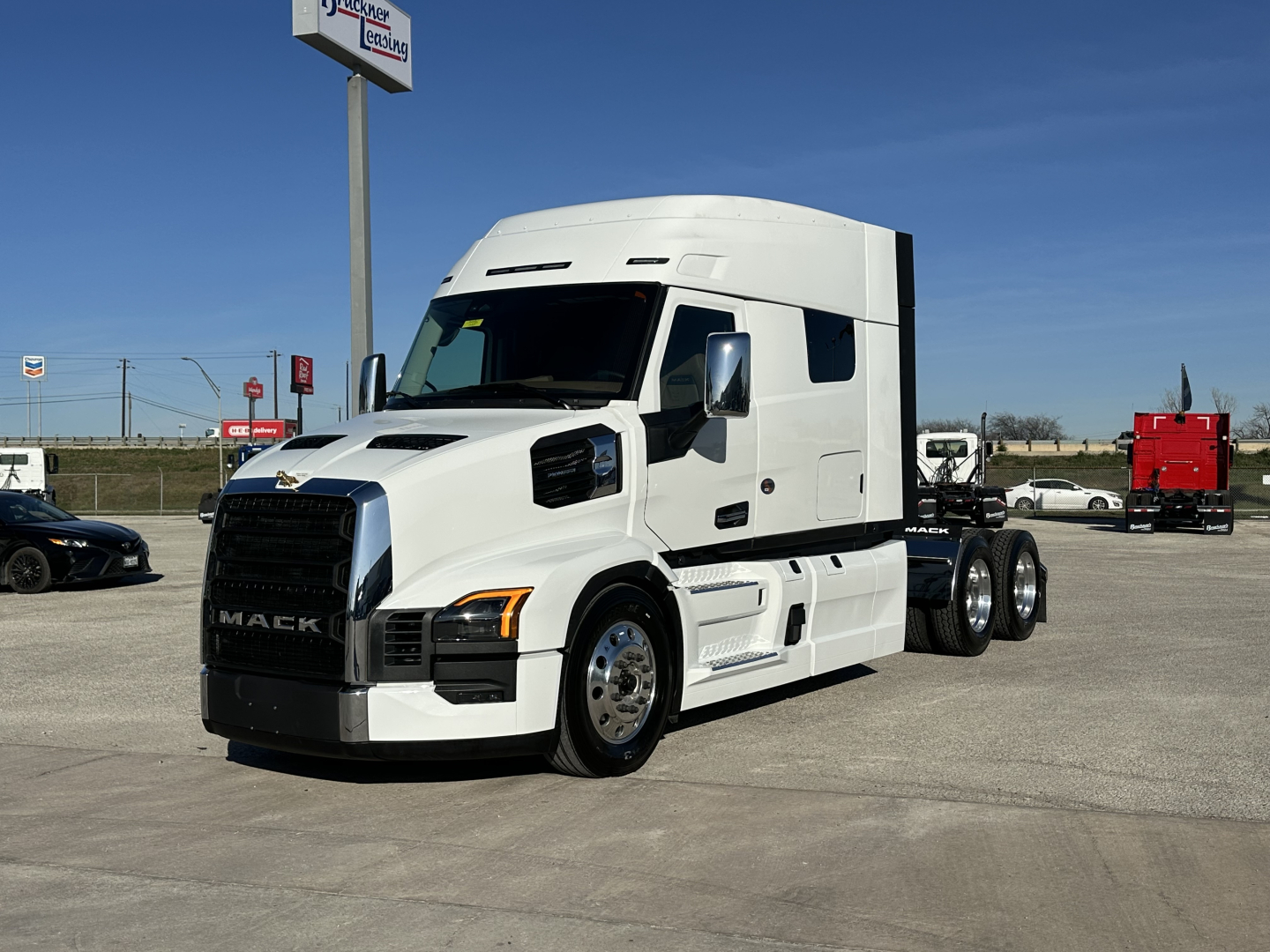 2026 Mack PR64T64 tractor-trailer in white, side view, with black grille and chrome wheels.