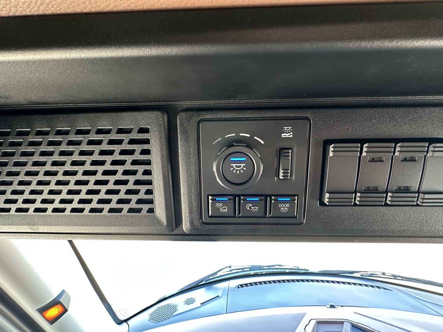 Dashboard panel showing light controls and switches in a Mack PR64T64 truck cab. Visible text includes circular headlight dial and various toggle switches.