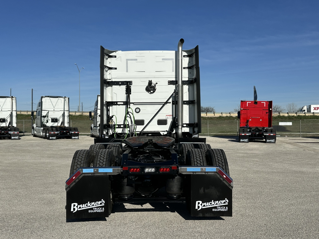 Truck rear view of a 2026 Mack PR64T64 tractor showing fifth-wheel area, chassis, dual rear wheels, mudflaps with Buckner branding, and back of sleeper cab.