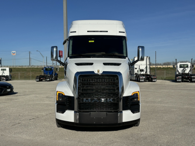 Mack PR64T64 conventional sleeper truck front view with large grille and black bumper in a dealership lot.