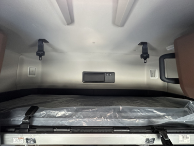 Interior sleeper cab storage area with a fixed shelf and tie-downs in a Mack PR64T64.