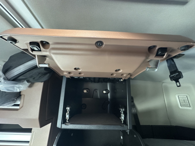 Cab interior of a 2026 Mack PR64T64 sleeper showing the open center console tray and dashboard