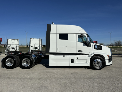 White Mack PR64T64 truck cab and chassis side view showing sleeper cab and dual rear axles under clear sky