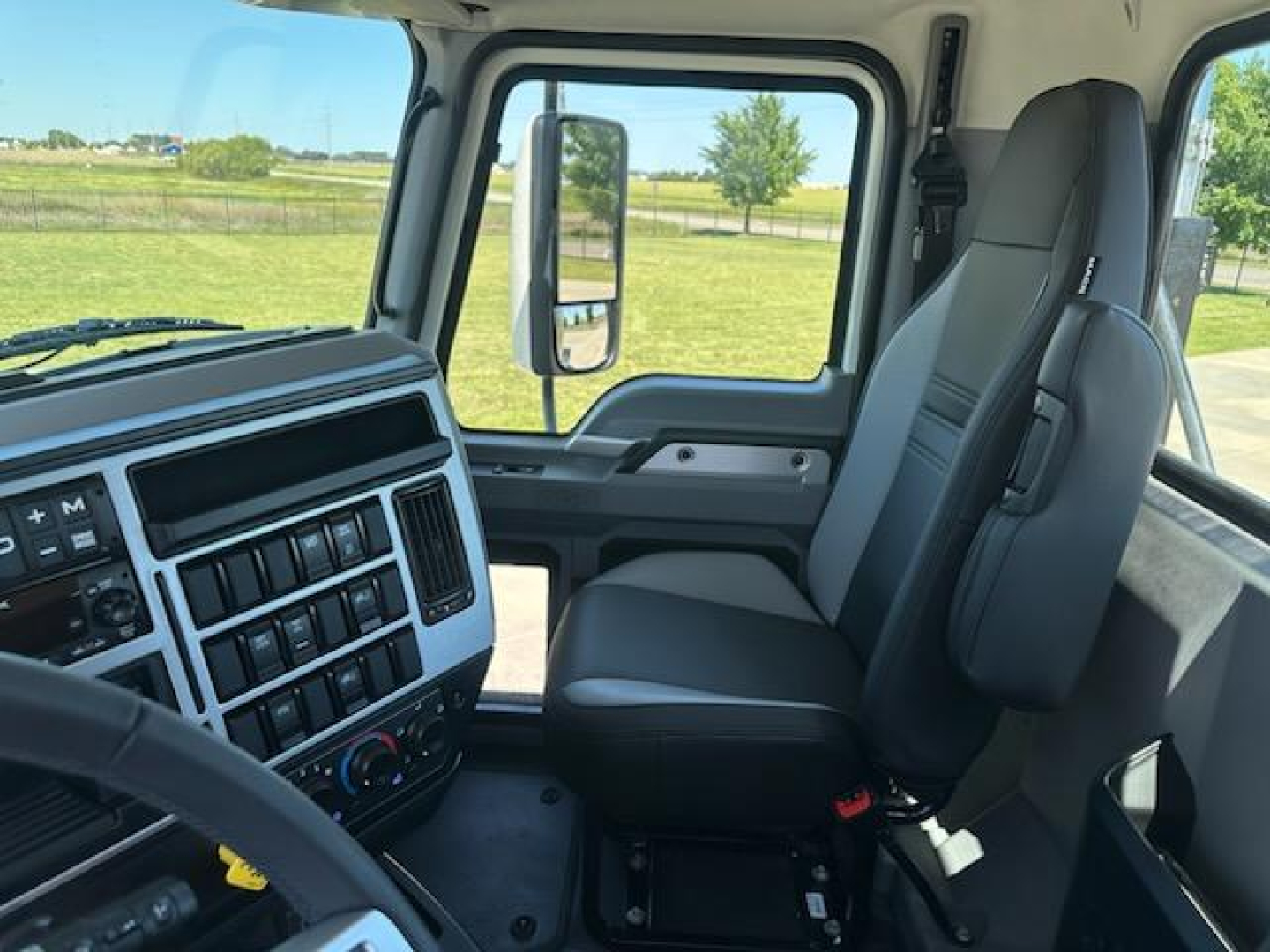Cab interior of a 2026 Mack AN64T truck showing steering wheel, dashboard with controls, and front passenger seat.