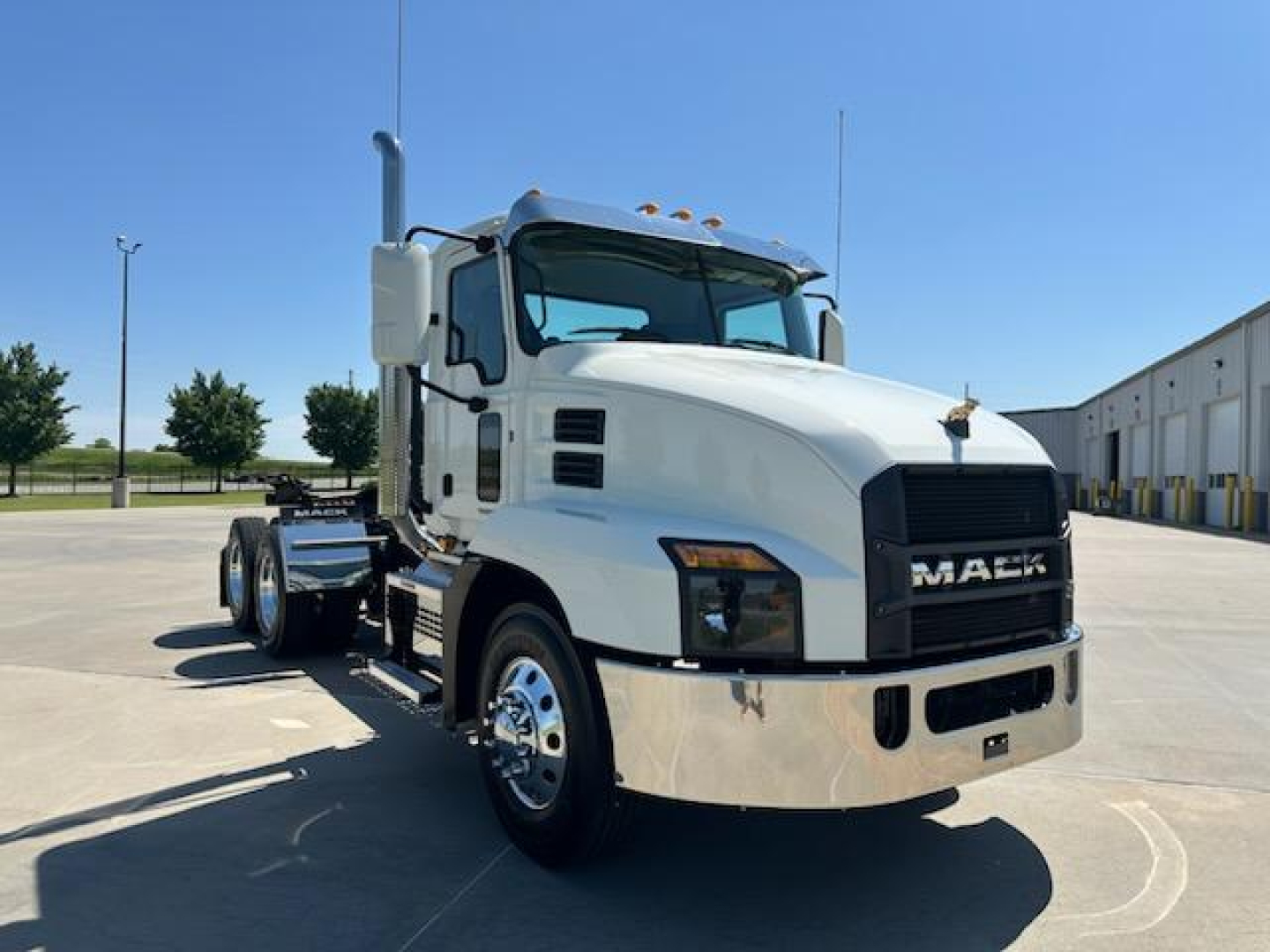 Mack AN64T conventional daycab truck in white with chrome bumper and grille, side view showing dual rear axles and large mirrors.