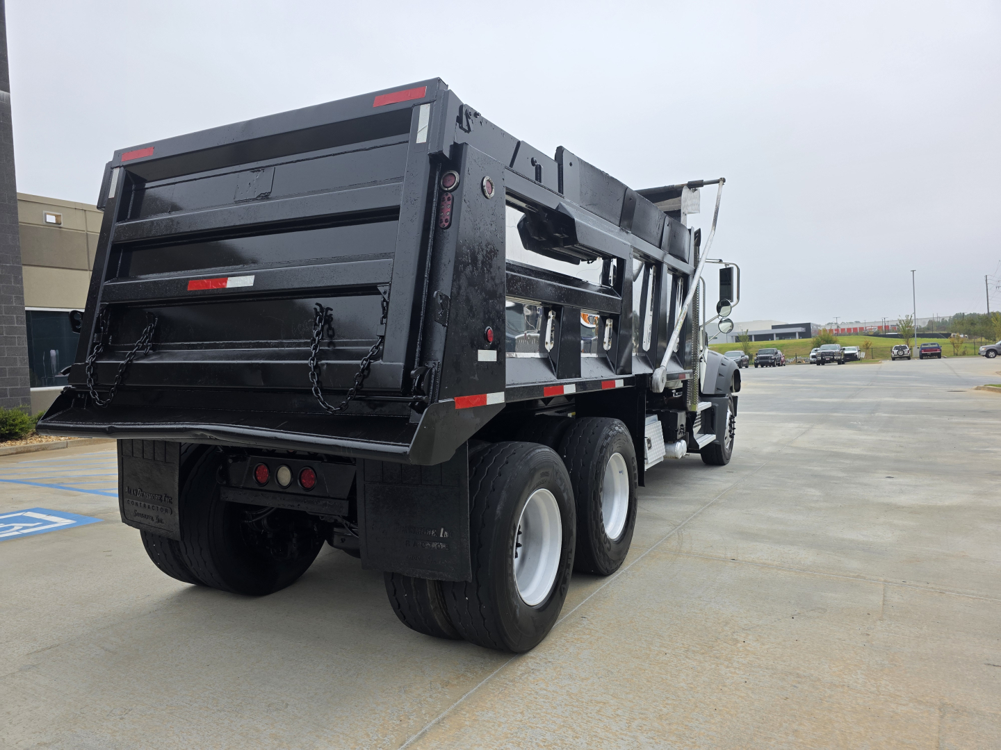 Truck rear view of a 2022 Mack GRANITE dump truck showing dual rear axles and dump bed.
