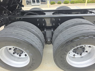 Mack Granite dump truck tandem rear axle and suspension showing dual tires and leaf springs with frame rails.