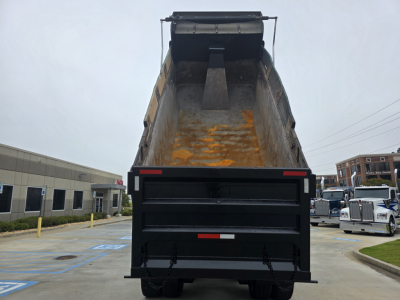 Truck bed of a Mack GRANITE dump truck showing empty bed with some rust stains and rear tailgate open.