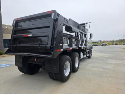 Truck rear view of a 2022 Mack GRANITE dump truck showing dual rear axles and dump bed.