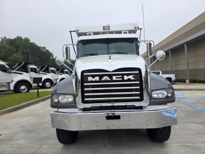 Front view of a white Mack Granite dump truck showing the large chrome grille with 'MACK' lettering, bumper, headlights, and side mirrors.