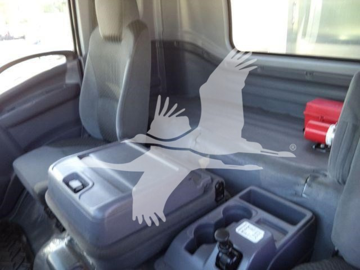 Isuzu FTR truck cabin interior showing driver's seat and center console with cup holder and storage compartments.