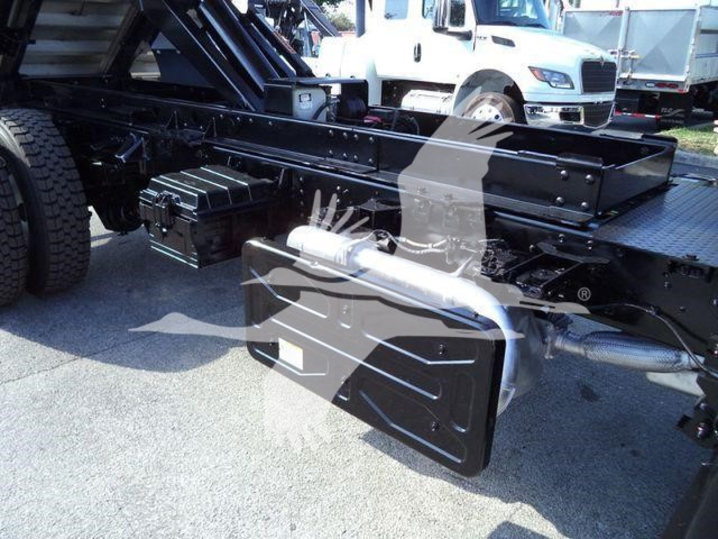 Isuzu FTR truck chassis showing undercarriage tools and fuel/air reservoirs with black metal framing and attachment boxes.