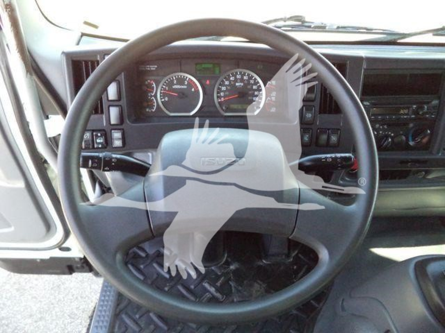 Isuzu truck cabin dashboard with steering wheel and instrument gauges visible