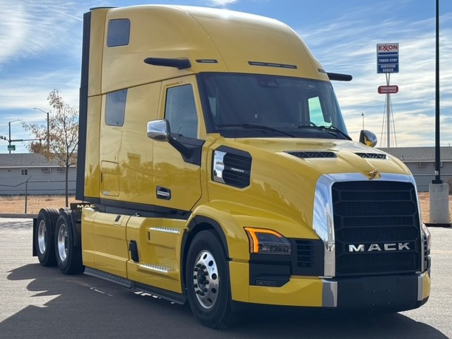 Mack PR64T76H conventional sleeper truck in yellow, front three-quarter view, showing cab and chassis with large grille and Mack emblem.