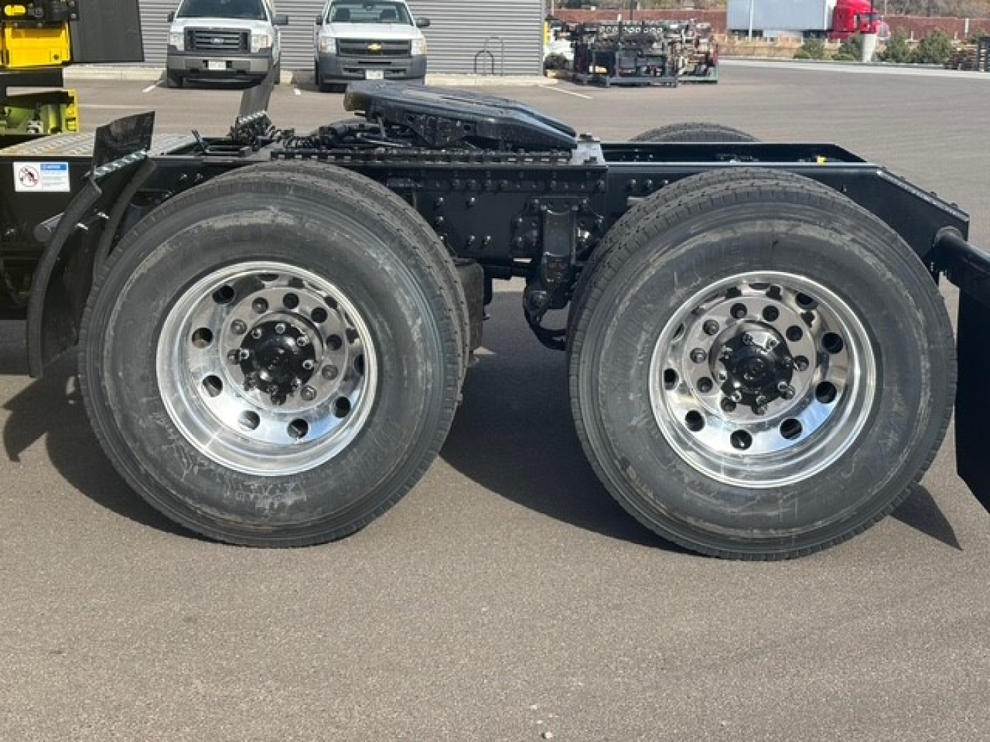 Twin rear axles of a Mack PR64T76H truck showing dual wheels and chrome rims.