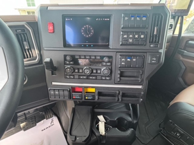 Dashboard of a 2026 Mack PR64T76H showing center touchscreen, multiple control panels, and storage compartments.